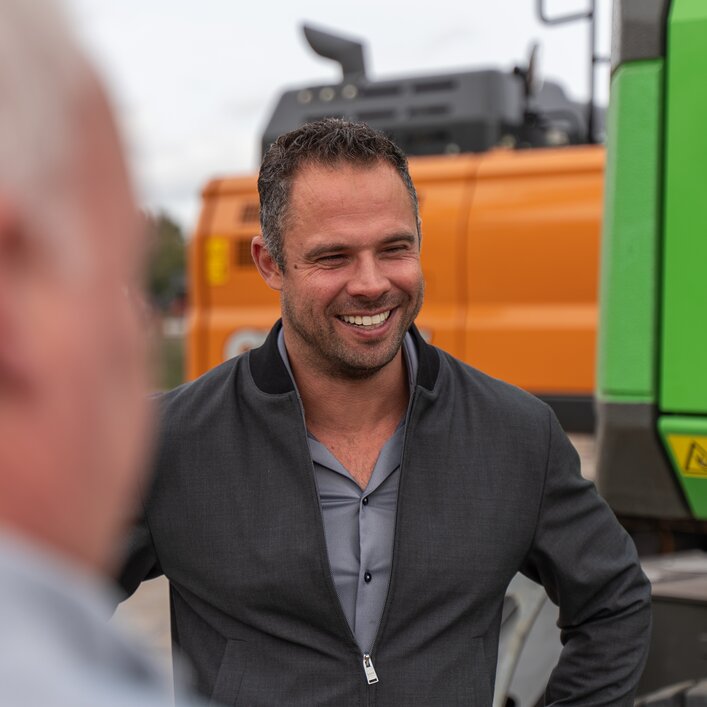 Photo of Frederik standing at a Sennebogen excavator 